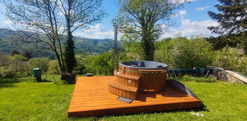 Ein runder Hot Tub auf der Terrasse, eingebettet in die atemberaubende Pracht der Natur in einer Berglandschaft