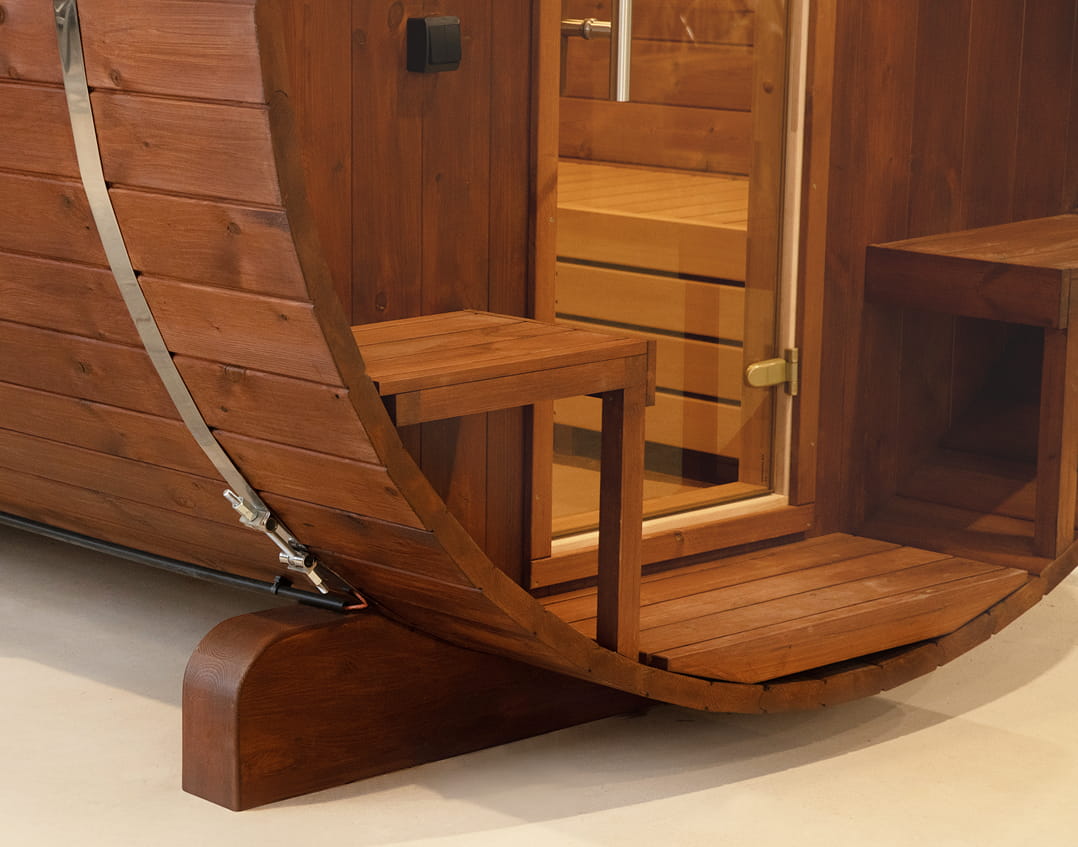 Wooden barrel sauna with a step leading into it