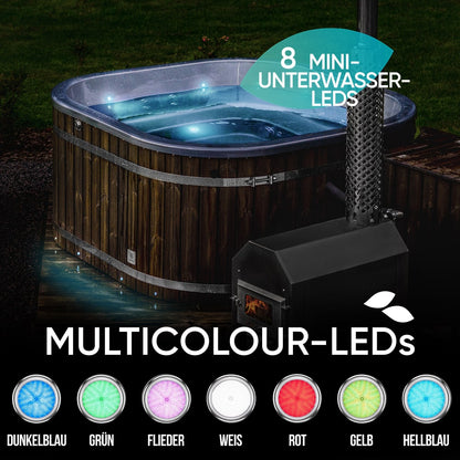 Night view of wood-fired hot tub with multicolour underwater LED lights and external stove with fire burning inside