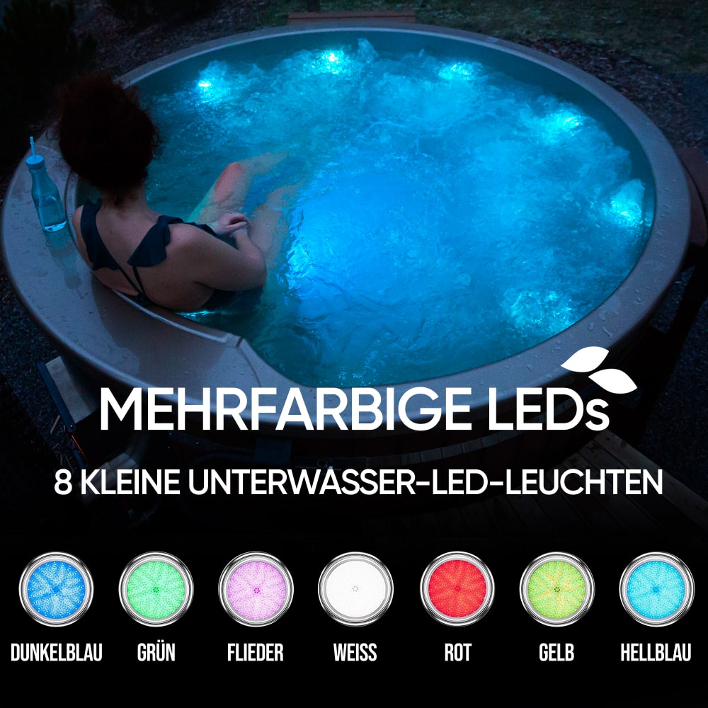 Evening view of person relaxing in round hot tub illuminated by blue underwater LED lights outdoors