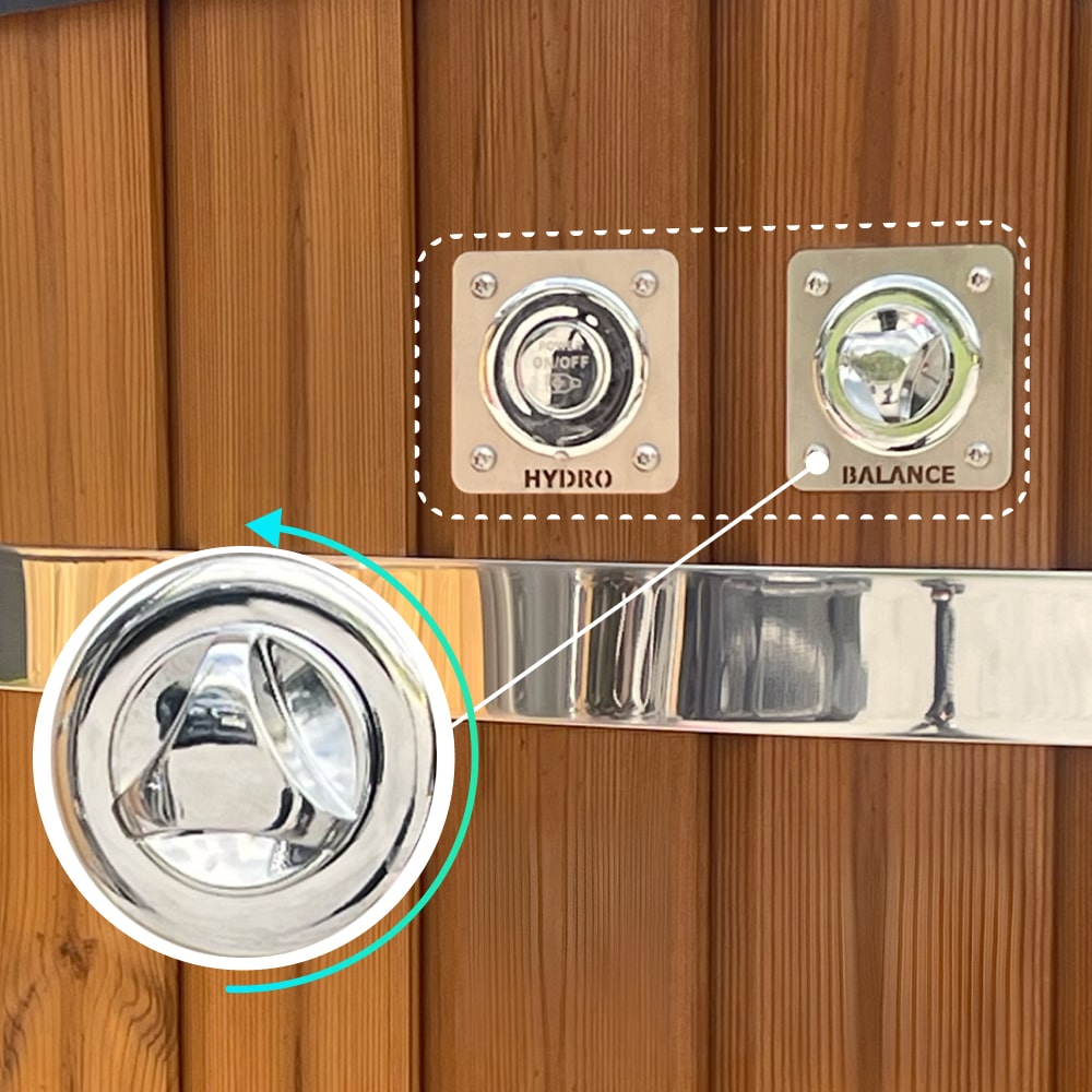 Nahaufnahme eines Hot-Tub-Bedienfelds mit verchromtem Hydro-Schalter und Balance-Regler auf einer Holzverkleidung