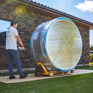 A man delivering a round hot tub and loading it onto a forklift 