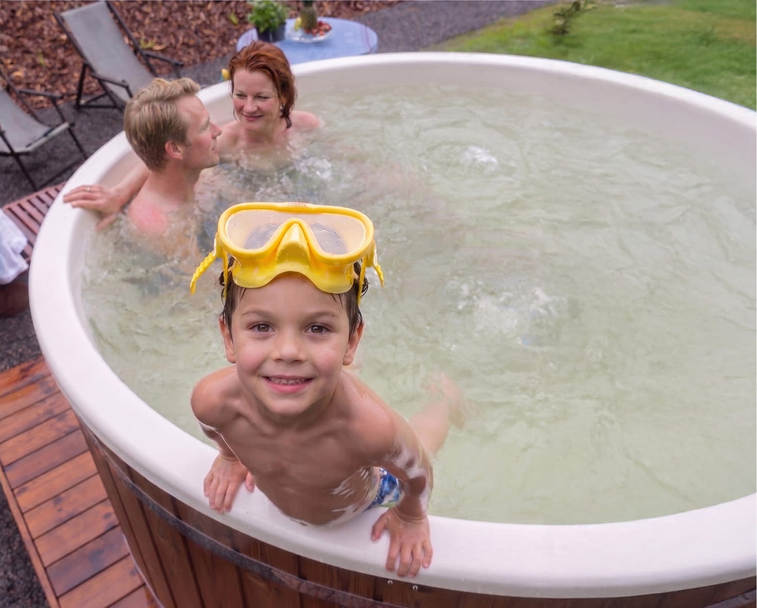 A child bathing with his parents in a tub with a white liner