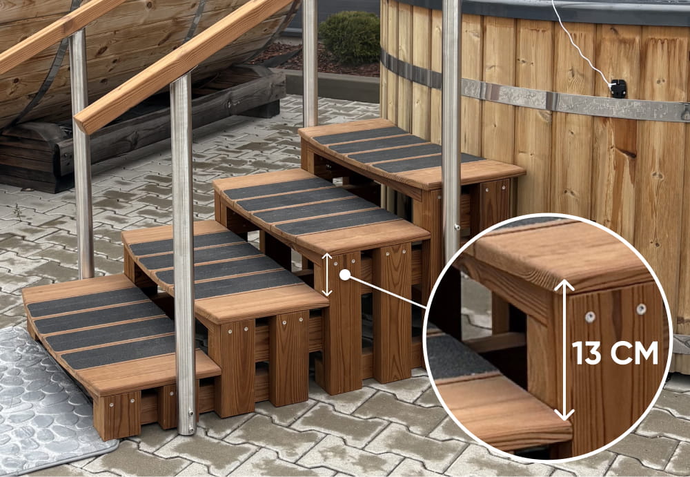 Die Premium-Trittstufen hot tub aus Thermoholz mit rutschfesten Trittflächen stehen neben einer hot tub-Trittstufe aus Holz; die Nahaufnahme zeigt die niedrige Stufenhöhe von 13 cm.
