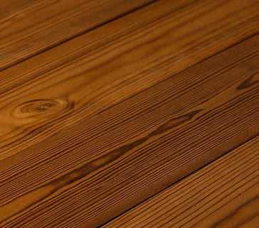 Nahaufnahme einer ThermoWood-Oberfläche mit sichtbarer Maserung und Textur.