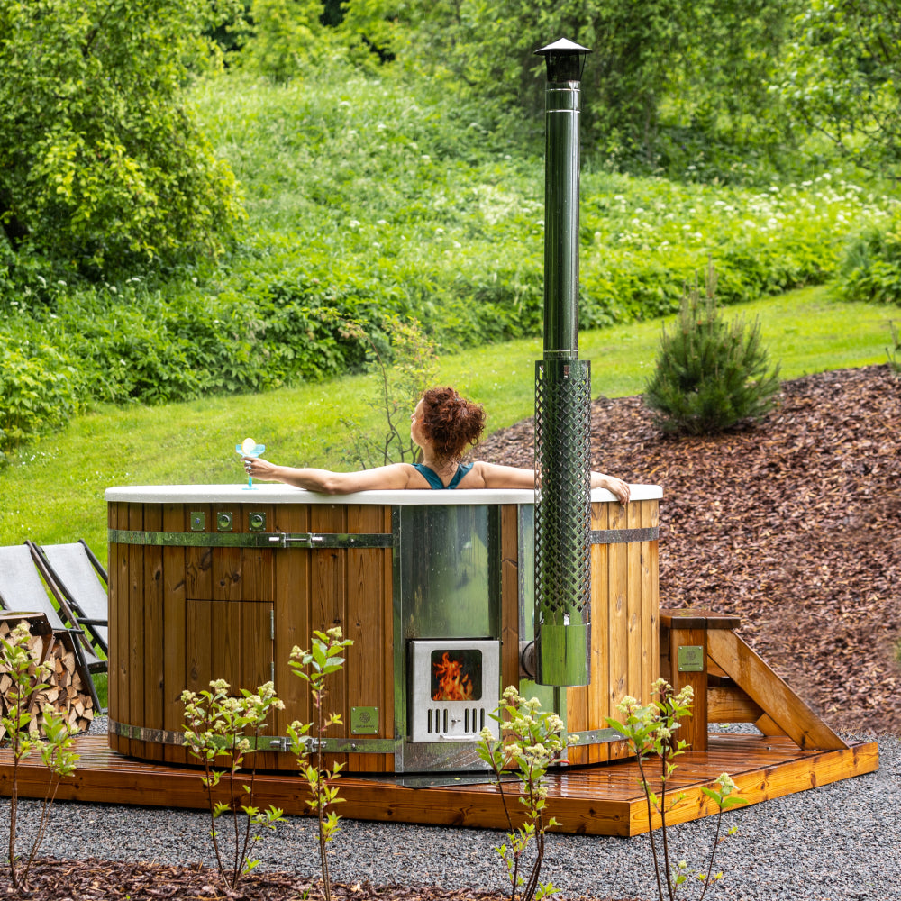 A woman soaking in a hot tub and enjoying the greenery around her