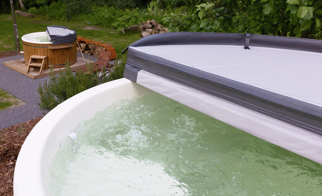 Whirlpool mit abgenommener Abdeckung, der das Wasser im Inneren zeigt, in einer Gartenanlage.