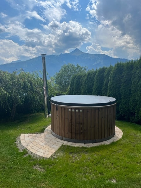 Gardenvity hot tub im Garten mit Bergblick.