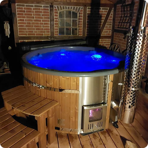 Hot tub with blue LED lighting  and thermowood cladding in a cozy indoor setting 