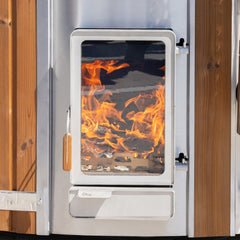 Wood-burning stove Verta with flames inside, surrounded by wooden panels of hot tub